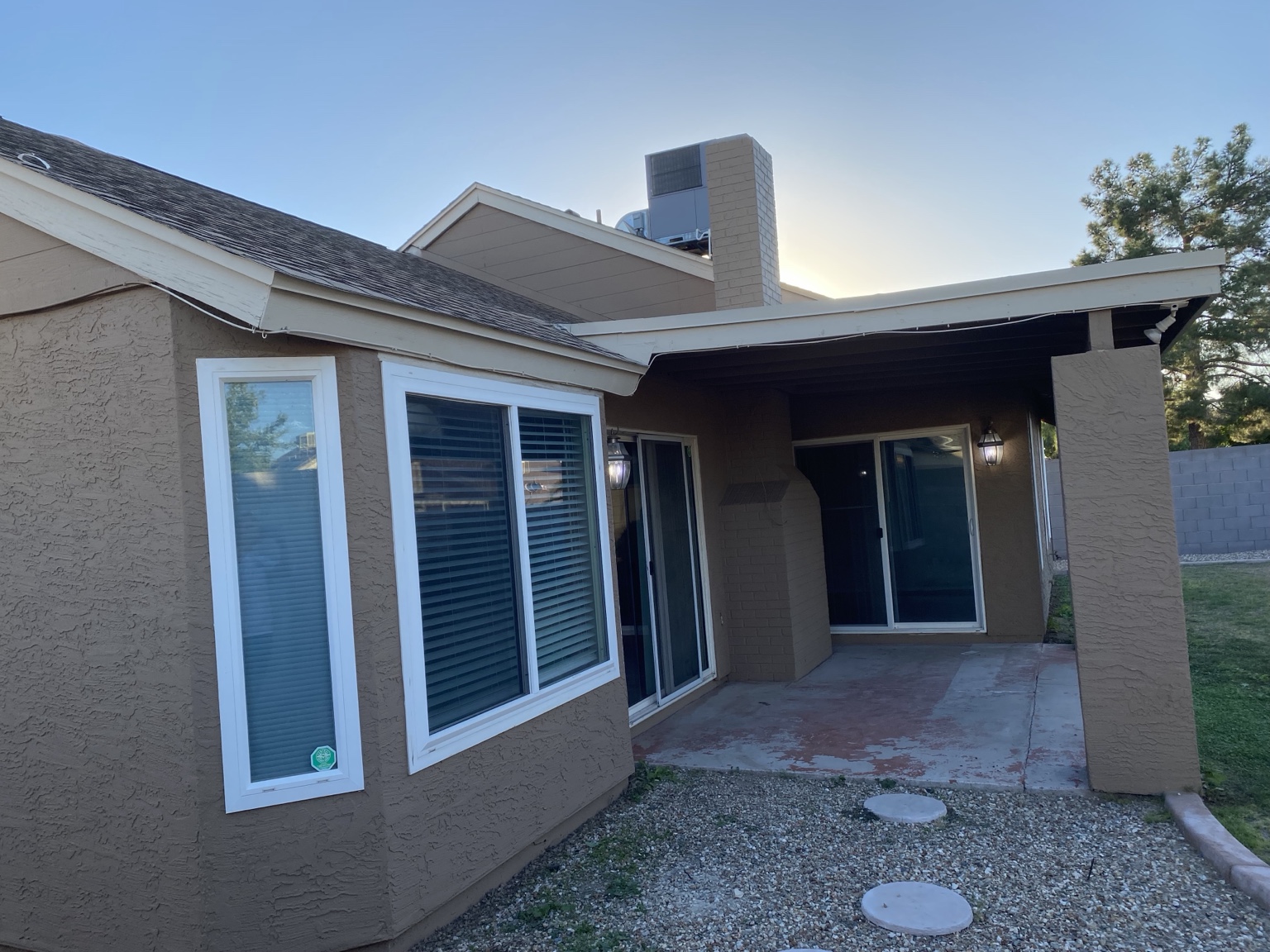 Patio with brown stucco walls and crisp white window trim