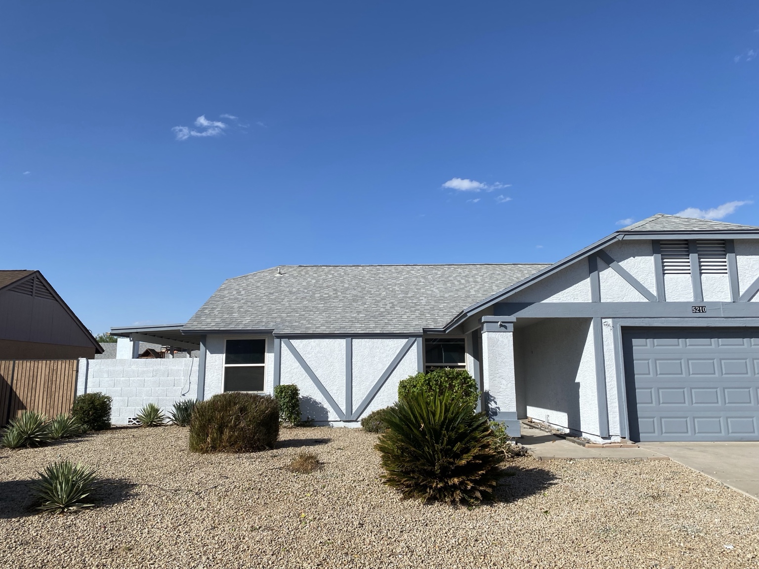 ROLL and GUN exterior painting project with white walls and contrasting gray trim